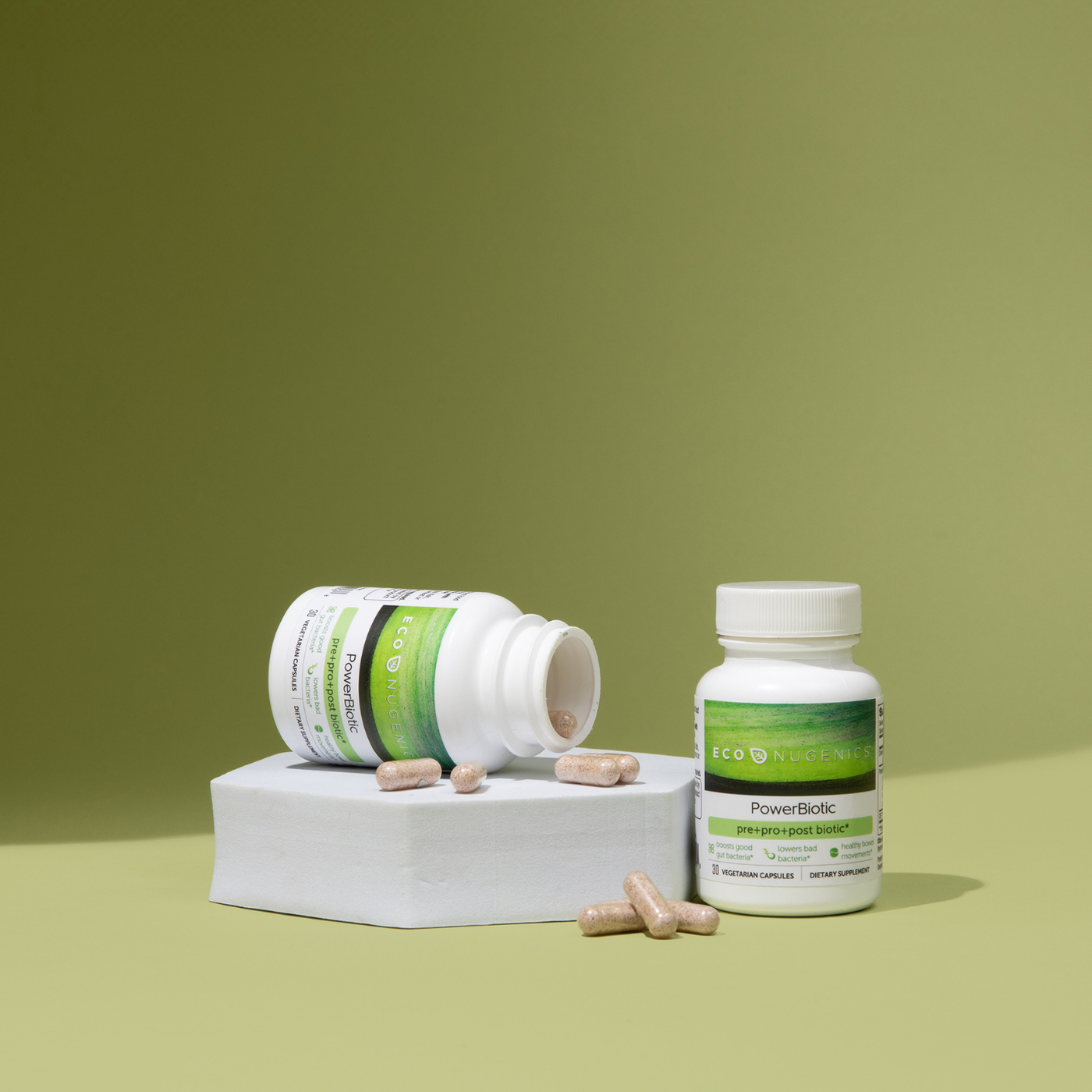 Two powerbiotic bottles with pills out and light green background