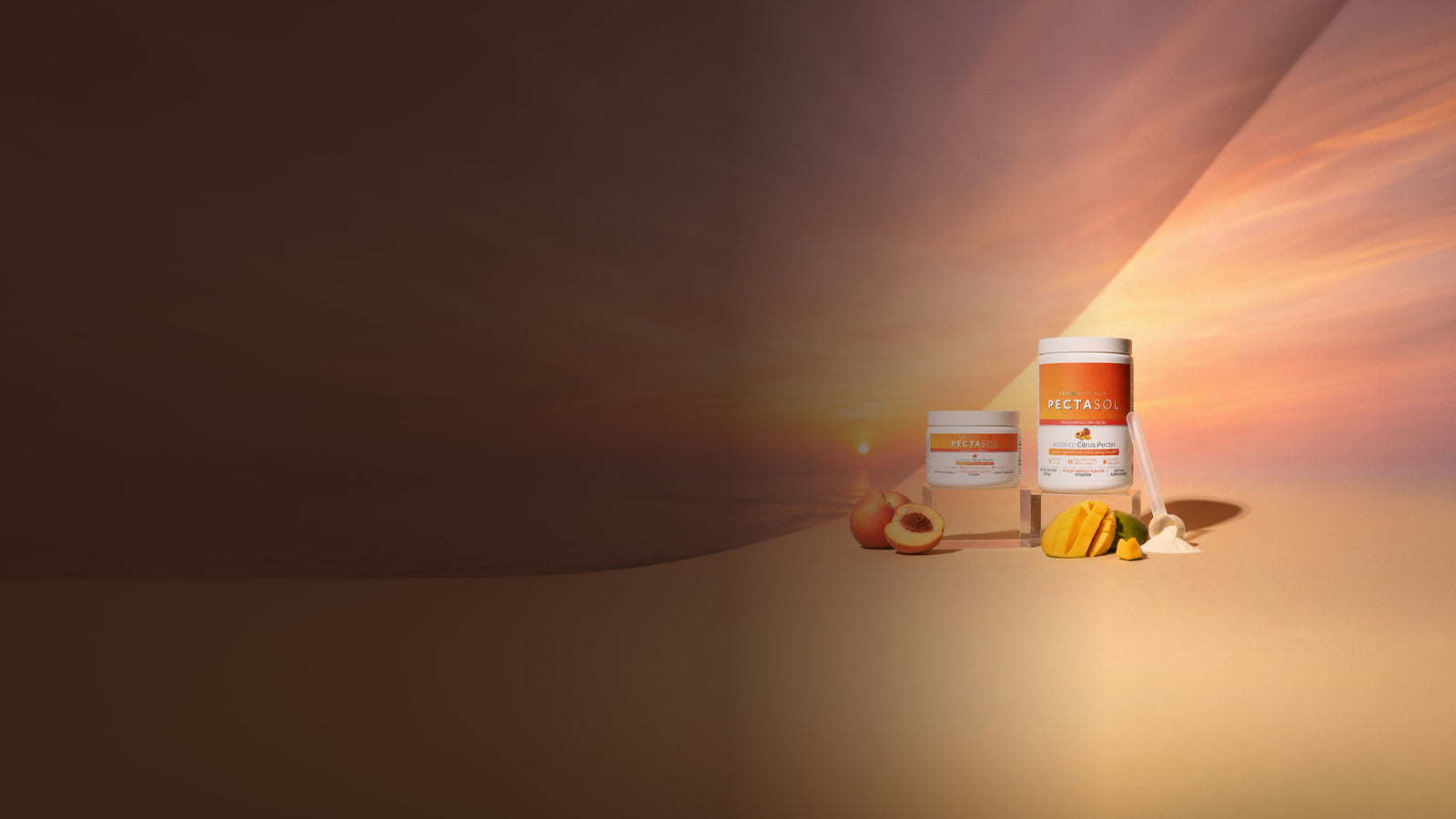 PectaSol Peach Mango powder with fresh peaches and mango on a beach at sunset